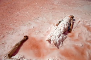 Iranians lying beside Urmia Lake with their bodies covered with salt