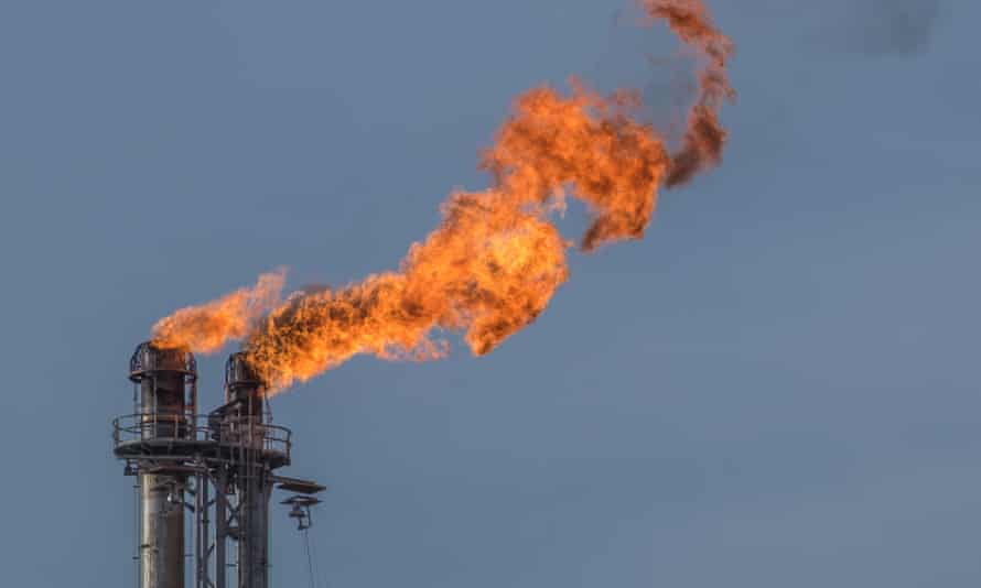 A flaming flare stack at a petroleum plant