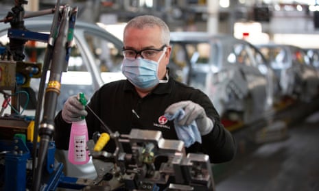 A member of staff at Vauxhall car factory cleaning and disinfecting a work station