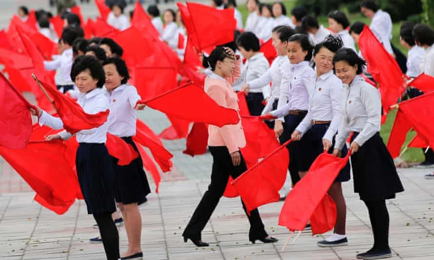 Girls practice dancing with red flags ahead of Friday’s celebration.