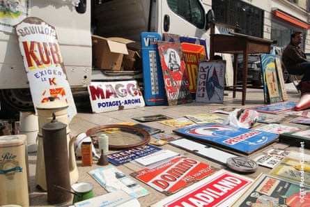 A stall at a market in Amiens with old signs and books.