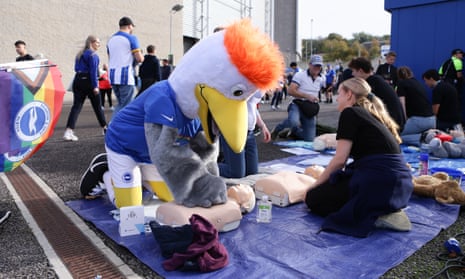 The Brighton mascot joins fans in taking part in CPR practice on dummies outside the American Express Community Stadium.