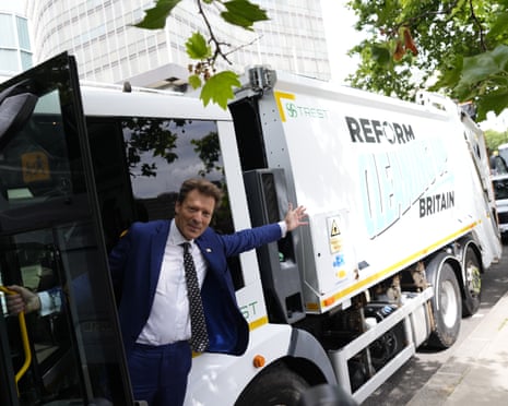 Richard Tice hangs out a refuse vehicle pointing to the side of it which reads: ‘Reform cleaning up Britain’