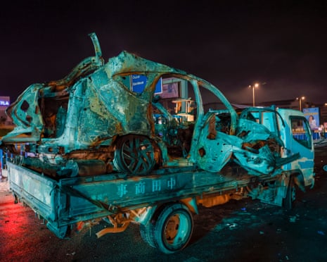 City workers with supporters of Hezbollah remove a burned vehicle from a street along the highway leading to Beirut international airport after it was hit by an Israeli strike on Wednesday