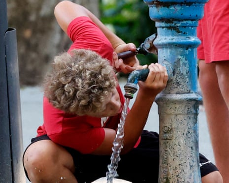 A boy hydrates with fresh water during a hot day in downtown Zagreb, Croatia.