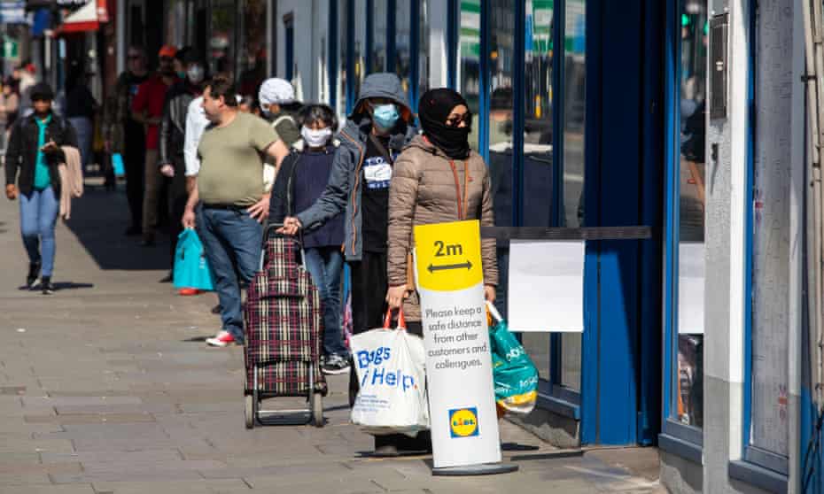 Shoppers queue at a supermarket in London