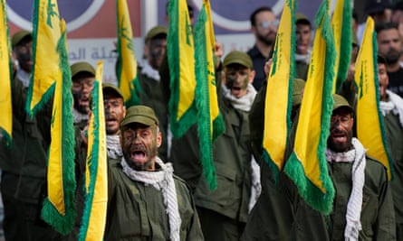 Hezbollah fighters raise flags at a funeral
