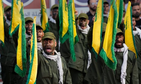 Hezbollah fighters rise their group flags and shout slogans, as they attend the funeral procession of two comrades killed by Israeli shelling, in Kherbet Selem village, south Lebanon.