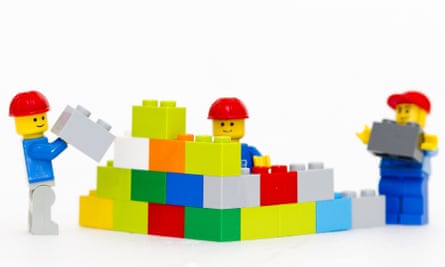 Tim pekerja figur Lego membangun tembok