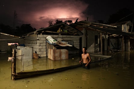 A resident wades through a flooded street caused by heavy rains from typhoon Toraji in Ilagan City, Isabela province, northern Philippines