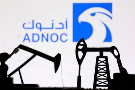 Abu Dhabi National Oil Company (Adnoc) logo behind miniature oilfield equipment.