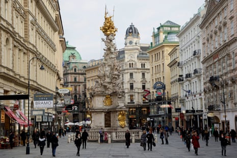 People walk down a Vienna shopping street, as the local government discusses to close non-essential shops for several days over Easter.