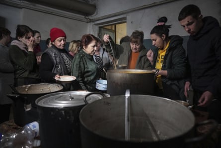 People queue to receive hot food in an improvised bomb shelter in Mariupol, 7 March