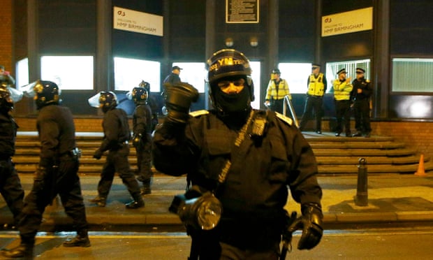 Police officers in riot gear stand outside the prison on Friday.