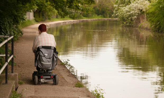 Disabled man using disability scooter on towpath in Warwickshire