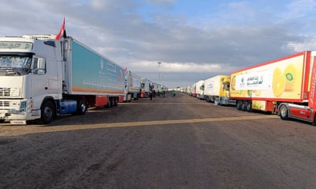 Um comboio de caminhões transportando ajuda humanitária de ONGs egípcias para os palestinos espera em frente à passagem de Rafah