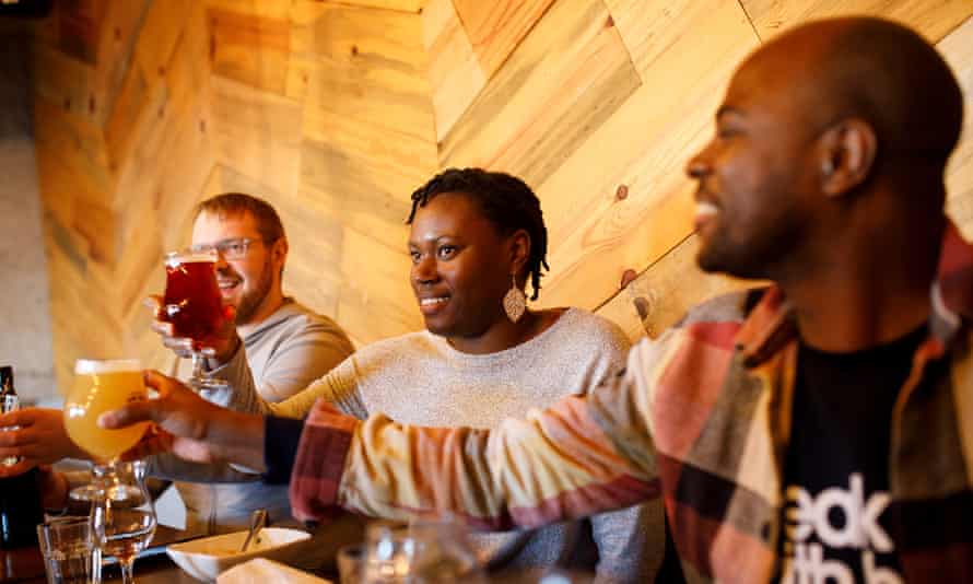 Three people raising glasses of craft beer