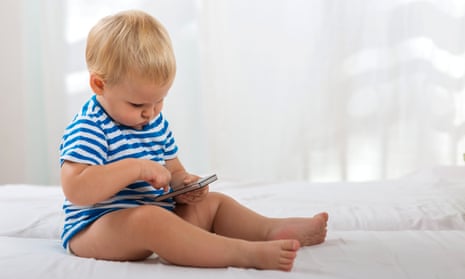 Baby in blue-striped t-shirt using a smartphone