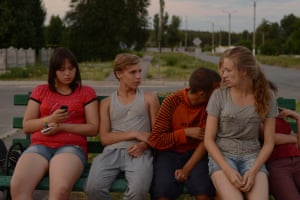 Five young people talking on a bench