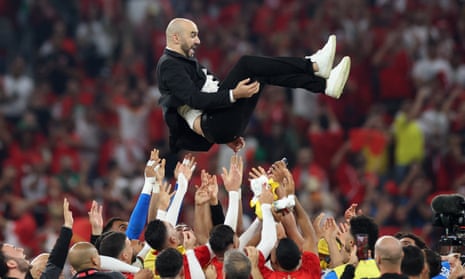Morocco coach Walid Regragui is thrown into the air by Morocco players as they celebrate qualifying for the knockout stages.