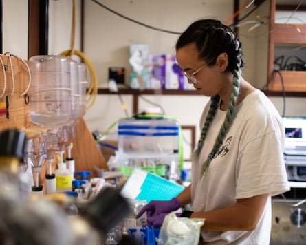 A young woman surrounded by scientific equipment in a lab