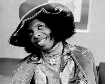 Dressed in a sequinned jacket and Stetson-style hat, Stone cocks his head and smiles widely