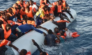 Migrants and refugees panic as they fall in the water during a rescue operation in the Mediterranean