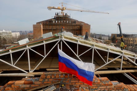 Russian flag flies in front of reconstruction work on a building roof