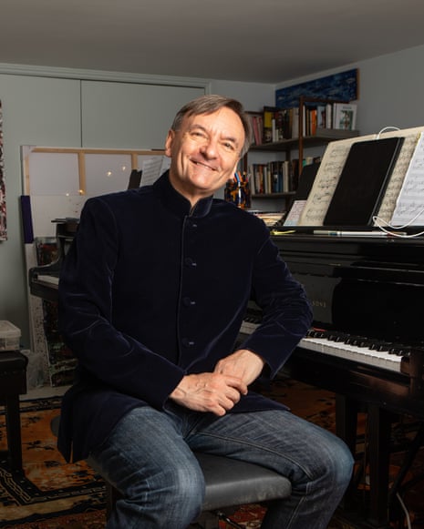 Stephen Hough sits at a grand piano with sheet music open in his studio