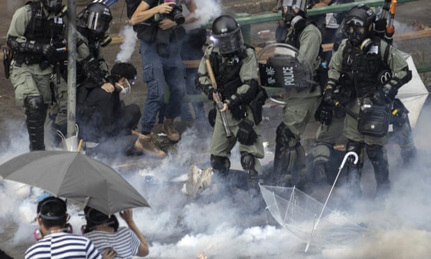 Riot police detain protesters amid clouds of tear gas at Polytechnic University.