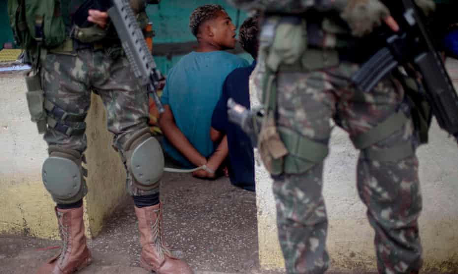 A suspect remains handcuffed after being arrested by Brazilian soldiers, during a joint operation at the Cidade de Deus (City of God) favela in Rio de Janeiro this month.