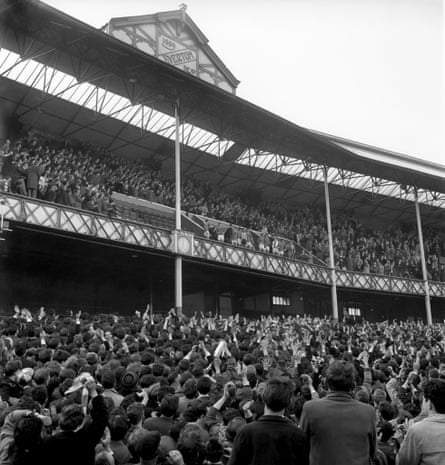 Everton fans flood Goodison Park after they won the 1963 Division One League championship. The team appeared in the directors box to celebrate with them