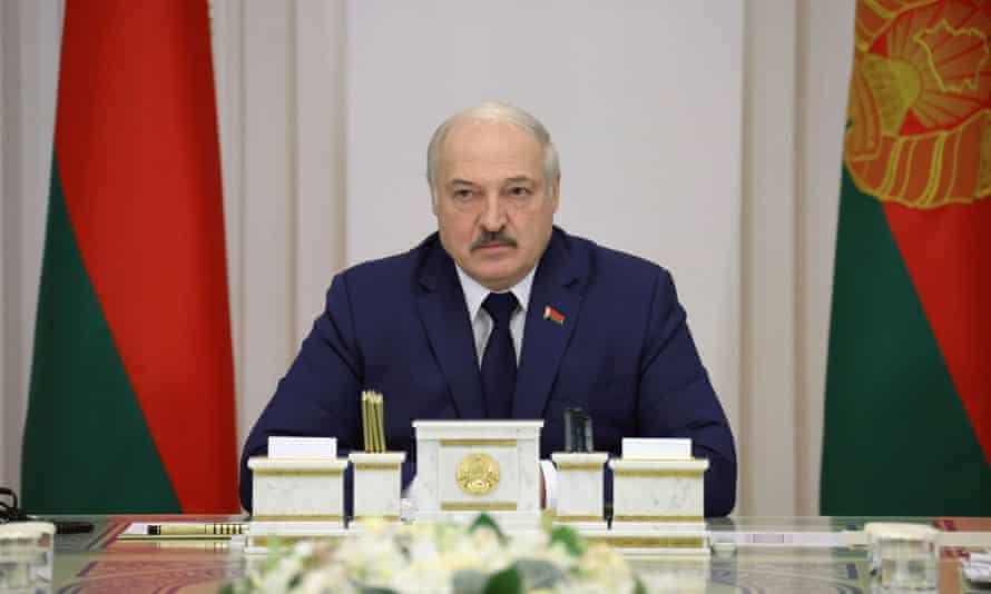 Belarusian President Alexander Lukashenko flanked by flags.