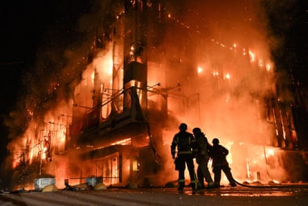 Firefighters are silhouetted in front of a burning shopping centre in Zaporizhzhia.