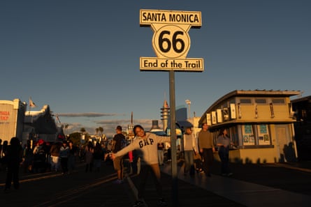 A visitor poses for photos with the ‘End of the trail’ Route 66 sign