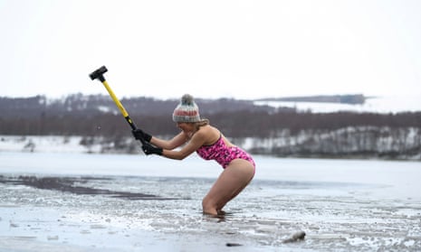 Nicky Goode using a sledgehammer to break the ice at Loch Insh in Scotland.