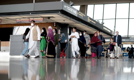 Refugees walk through the departure terminal to a bus at Dulles international airport after being evacuated from Kabul following the Taliban takeover of Afghanistan on 31 August 2021 in Dulles, Virginia. 