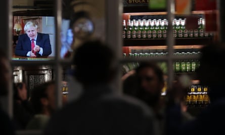 Customers at the Westminster Arms, near the House of Commons watch on as Boris Johnson gives his televised address on the latest coronavirus restrictions.