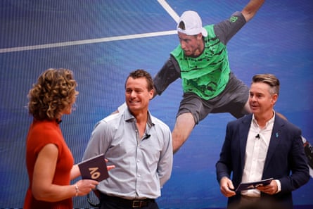 Samantha Stosur, Lleyton Hewitt and Todd Woodbridge speak at the Australian Open 2024 launch in front of screen showing Hewitt playing on court