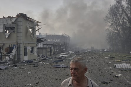 A man walks past destroyed houses after a Russian strike in the Bucha district