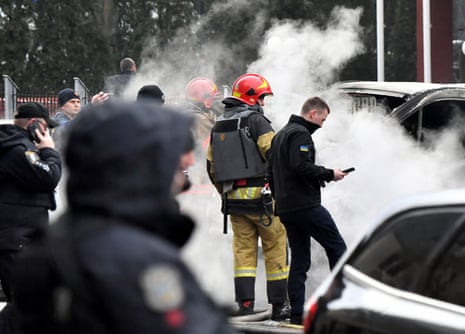 Police experts and rescuers inspect the site of fallen fragments of Russian rockets near a multi-storey residential building in Kyiv.