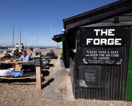 Customers sit on benches beside the Forge