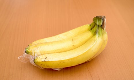Bananas wrapped in plastic on a table