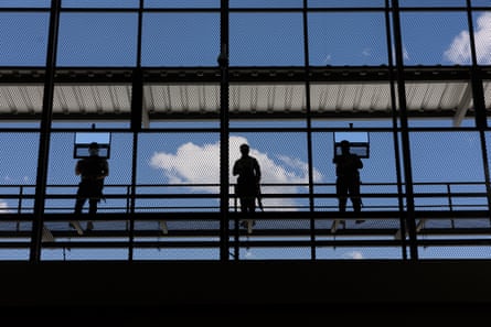 three men silhouetted on a gangway