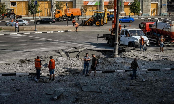 Passersby gather around the crater in Kharkiv