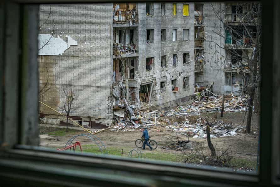 A resident walks with a bicycle in the heavily damaged neighbourhood of Chernihiv.