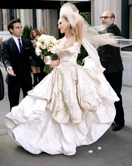Image from TV series showing character of Carrie Bradshaw in full-length white gown with voluminous skirts and a net veil