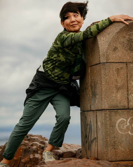 A woman poses for a photograph at the top of Arthur's seat an extinct volcano near Edinburgh city center