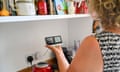 Woman looking at British Gas Smart Meter in her kitchen
