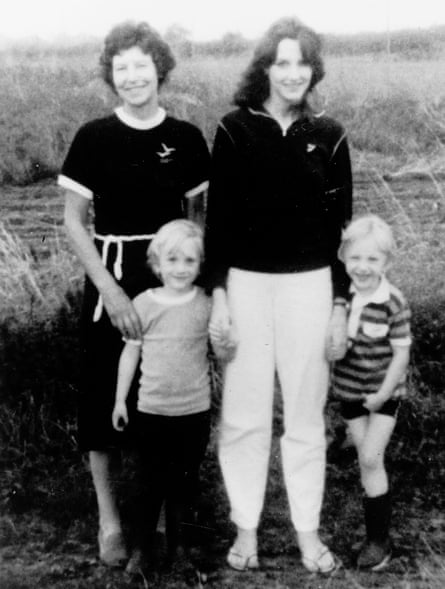 Two women with dark hair, and two young blond boys, standing in a field